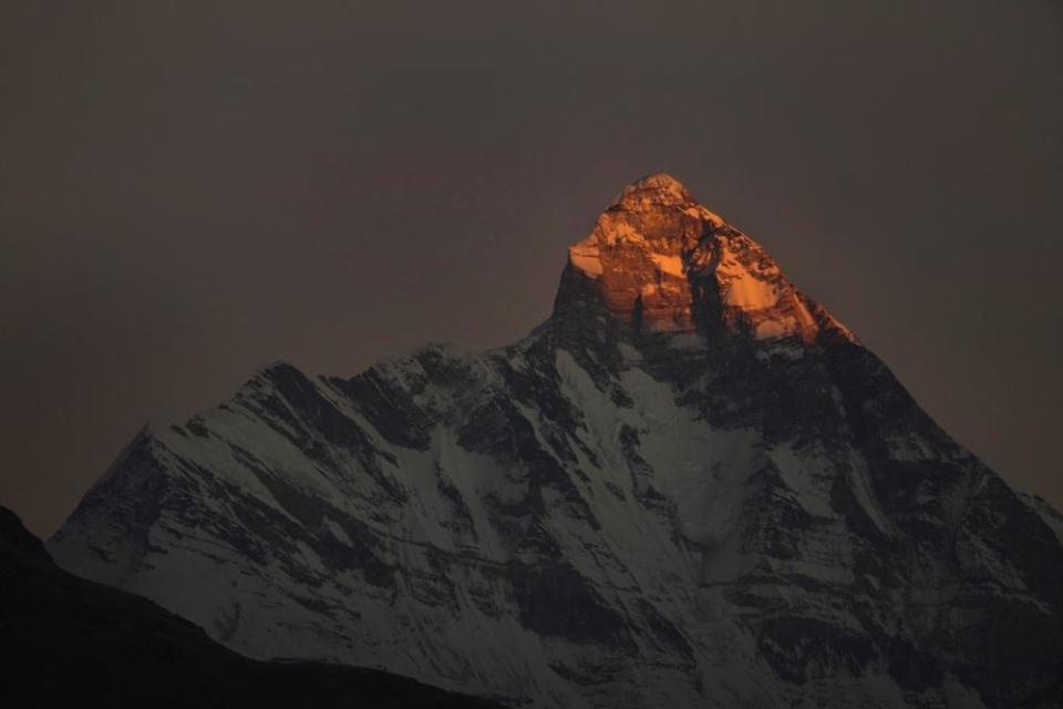The last rays of the setting sun fall on the peak of Nanda Devi in Uttarakhand state