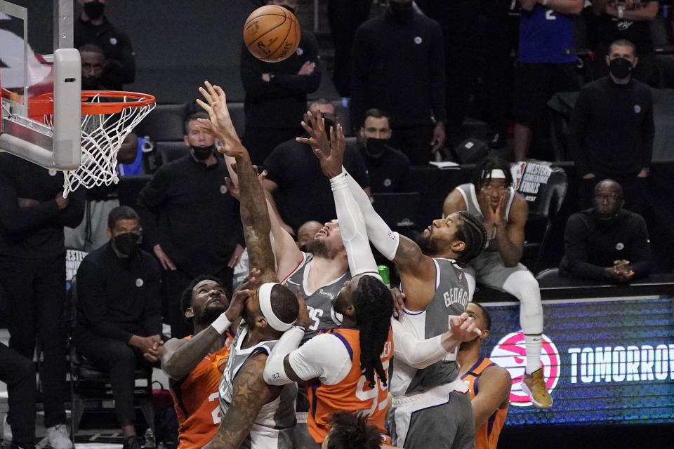 Members of the Los Angeles Clippers and Phoenix Suns battle for a rebound as the Clippers' guard Terance Mann, right, watches during the closing seconds in Game 4 of the NBA basketball Western Conference Finals Saturday, June 26, 2021, in Los Angeles. (AP Photo/Mark J. Terrill)