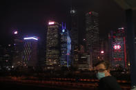 A man wearing face mask looks at night view of Hong Kong's business district Thursday, May 28, 2020. China’s legislature endorsed a national security law for Hong Kong on Thursday that has strained relations with the United States and Britain and prompted new protests in the territory. (AP Photo/Kin Cheung)