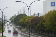 Commuters drive by as picketers strike outside of the General Motors assembly plant, Tuesday, Oct. 24, 2023, in Arlington, Texas. The United Auto Workers union is turning up the heat on General Motors as 5,000 workers walked off their jobs at the highly profitable SUV factory. (AP Photo/Julio Cortez)