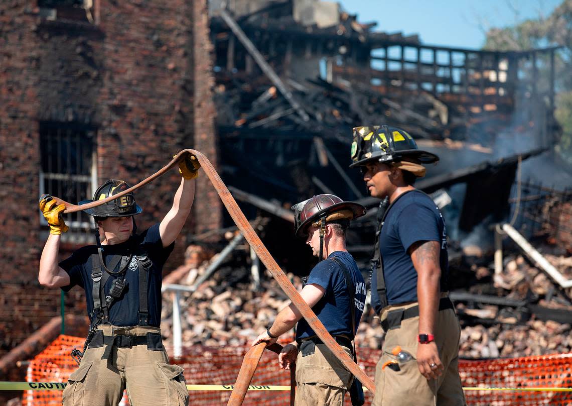 Firefighters work the scene of a fire at a building near the intersection of East Main Street and Holman Street on Thursday, May 2, 2024, in Durham, N.C.