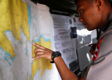 An Indonesian police officer studies a map in the search and rescue command center for the Lion Air flight JT610 crash, at Tanjung Priok port in Jakarta, Indonesia, October 30, 2018. REUTERS/Edgar Su