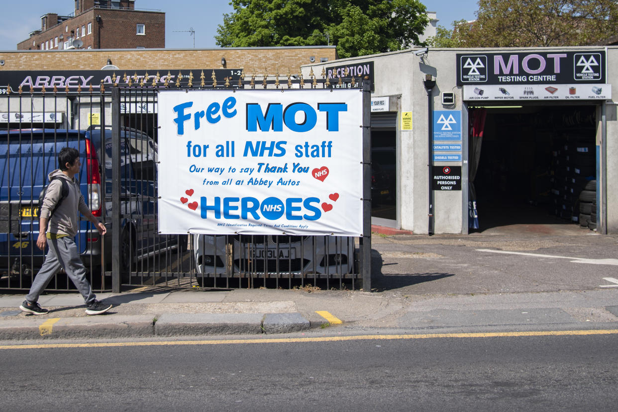 A man walks past a garage offering free MOT's for all NHS (National Health Service) staff on 23th April 2020 in London, United Kingdom.There have been almost 133,495 reported cases of the COVID-19 coronavirus in the United Kingdom and almost 19,000 deaths. The country is in its fifth week of lockdown measures aimed at slowing the spread of the virus. (photo by Claire Doherty/In Pictures via Getty Images)