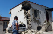 <p>A person stands in front of a damaged house after an earthquake hits the island of Ischia, off the coast of Naples, Italy, Aug. 22, 2017. (Photo: Ciro De Luca/Reuters) </p>