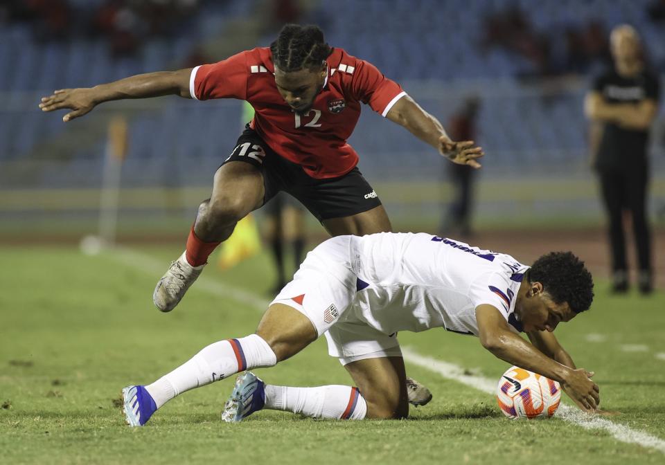 United States' Malik Tillman, down, fights for the ball with Trinidad and Tobago's Daniel Phillips, top, during a CONCACAF Nations League quarterfinal soccer match at Hasely Crawford Stadium in Port of Spain, Trinidad and Tobago, Monday, Nov. 20, 2023. (AP Photo/Azlan Mohammed)