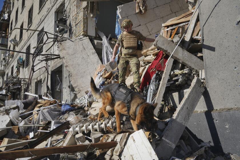 A rescue worker with a dog search for victims in a damaged apartment building after it was hit by Russian air bomb in Kharkiv, Ukraine, Saturday, June 22, 2024. At least three people were killed in a Russian bomb attack on Ukraine's second city, Kharkiv, on Saturday afternoon, Ukrainian President Volodymyr Zelenskyy said. (AP Photo/Andrii Marienko)