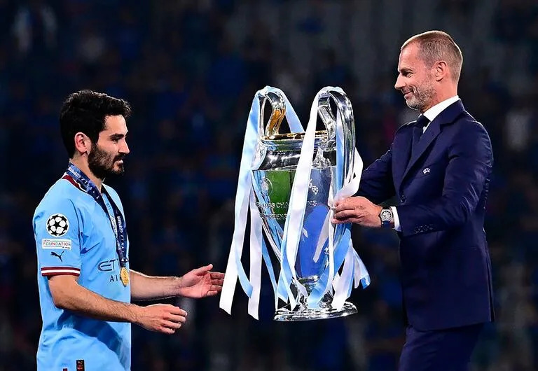 Ilkay Gündogan recibe de Aleksander Ceferin la Orejona; otros tiempos: el turco ya no está en Manchester City, que ya no es el monarca de la Champions League, y que puede terminar pasando de campeón de la Premier a descendido.