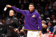 Phoenix Suns guard Devin Booker (1) cheers on his team during the first half of an NBA basketball game against the Brooklyn Nets, Saturday, Nov. 27, 2021, in New York. (AP Photo/Jessie Alcheh)