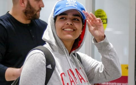 Saudi teenager Rahaf Mohammed arrives at Toronto Pearson International Airport in January wearing a Canada sweatshirt after the country offered her asylum - Credit: REUTERS/Carlos Osorio