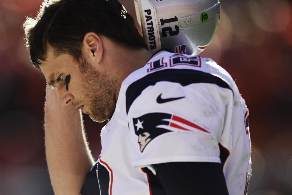 New England Patriots quarterback Tom Brady walks off the field during the following the first half of the AFC Championship NFL playoff football game against the Denver Broncos in Denver, Sunday, Jan. 19, 2014. (AP Photo/Joe Mahoney)