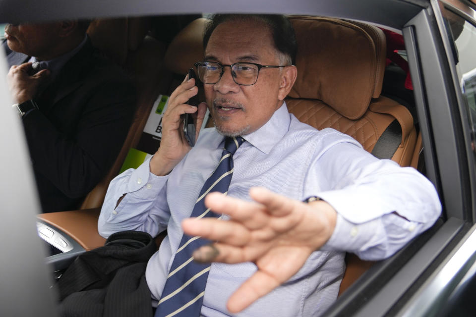 Opposition leader Anwar Ibrahim, talks on a phone as he leaves his office in Kuala Lumpur, Malaysia, Tuesday, Nov. 22, 2022. Malaysia’s election uncertainty deepened Tuesday after a political bloc refused to support either reformist leader Anwar Ibrahim or rival Malay nationalist Muhyiddin Yassin as prime minister, three days after divisive polls produced no outright winner. (AP Photo/Vincent Thian)