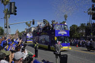 Confetti flies as buses carrying Los Angeles Rams players and coaches drive past fans during the team's victory parade in Los Angeles, Wednesday, Feb. 16, 2022, following their win Sunday over the Cincinnati Bengals in the NFL Super Bowl 56 football game. (AP Photo/Marcio Jose Sanchez)