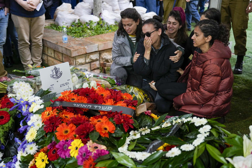 Raya, wife of Israeli reserve solider Sergeant major Eliran Yeger, mourns in grief around the grave during his funeral in Kiryat Shaul military cemetery in Tel Aviv, Israel, Sunday, Jan. 28, 2024. Yeger, 36, was killed during Israel's ground operation in the Gaza Strip, where the Israeli army has been battling Palestinian militants in the war ignited by Hamas' Oct. 7 attack into Israel. (AP Photo/Ariel Schalit)