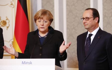 Germany's Chancellor Angela Merkel (L) and France's President Francois Hollande address the media after taking part in peace talks on resolving the Ukrainian crisis in Minsk, February 12, 2015. REUTERS/Grigory Dukor