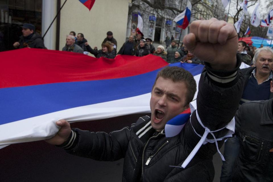 Local residents carry Russian flags and shout slogans rallying through the streets of Crimean capital Simferopol, Ukraine, on Saturday, March 1, 2014. Russian President Vladimir Putin asked parliament Saturday for permission to use the country’s military in Ukraine, moving to formalize what Ukrainian officials described as an ongoing deployment of Russian military on the country’s strategic region of Crimea. (AP Photo/Ivan Sekretarev)