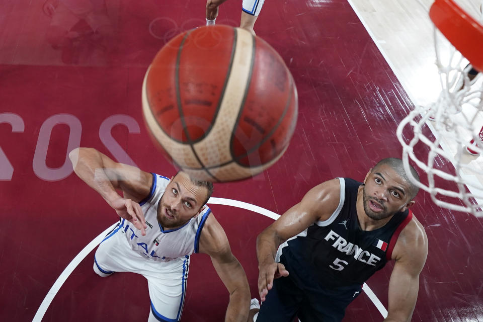 Italy's Stefano Tonut, left, and France's Nicolas Batum (5) battle for a rebound during a men's basketball quarterfinal round game at the 2020 Summer Olympics, Tuesday, Aug. 3, 2021, in Saitama, Japan. (AP Photo/Charlie Neibergall, Pool)