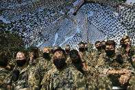 Cadets wear masks as they sit under camouflage netting, Friday, Aug. 7, 2020, in West Point, N.Y. The pandemic is not stopping summer training at the U.S. Military Academy. (AP Photo/Mark Lennihan)