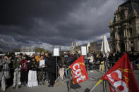 Visitors wait in line as workers of the culture industry demonstrate outside the Louvre museum Monday, March 27, 2023 in Paris. President Emmanuel Macron inflamed public anger by sending his already unpopular plan to raise the retirement age by two years, from 62 to 64, through parliament without a vote. (AP Photo/Christophe Ena)