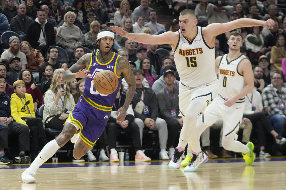 Utah Jazz guard Jordan Clarkson, left, drives around Denver Nuggets center Nikola Jokic (15) during the second half of an NBA basketball game Wednesday, Jan. 10, 2024, in Salt Lake City. (AP Photo/Rick Bowmer)