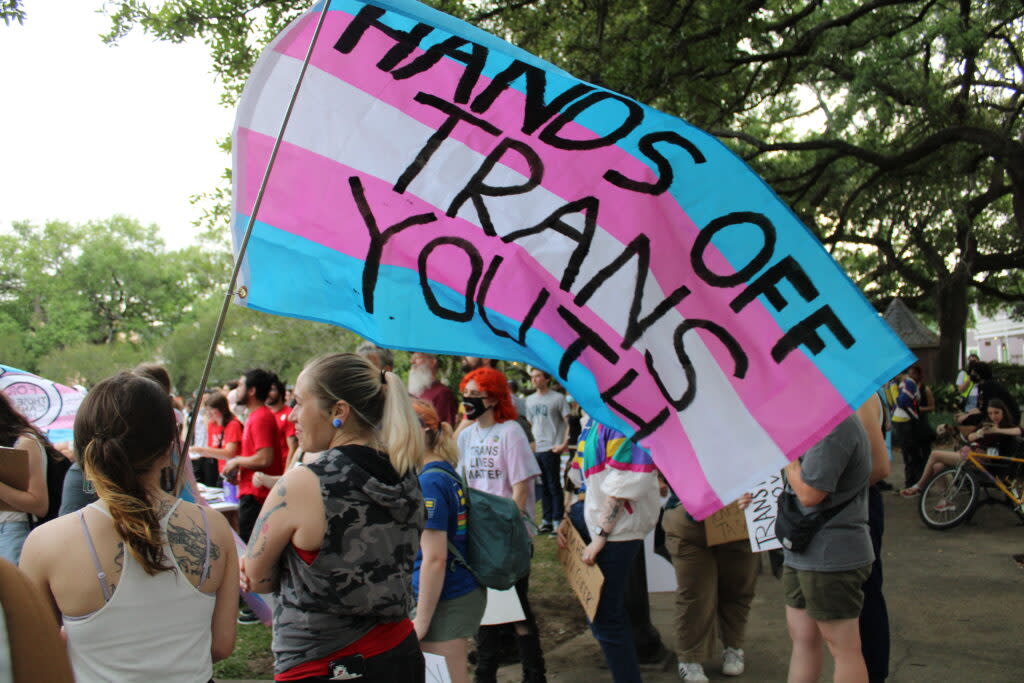 A transgender Pride flag is covered with the words "Hands Off Trans Youth" at Washington Square Park, where hundreds people gathered for a march to mark Transgender Day of Visibility.