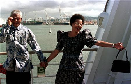 South African President Nelson Mandela (L) adjusts his sunglasses as he and his companion Graca Michel set sail aboard the QE II cruise ship in Durban harbor, for Cape Town, in this file picture taken March 29, 1998. Mandela has passed away on December 5, 2013 at the age of 95. REUTERS/Files