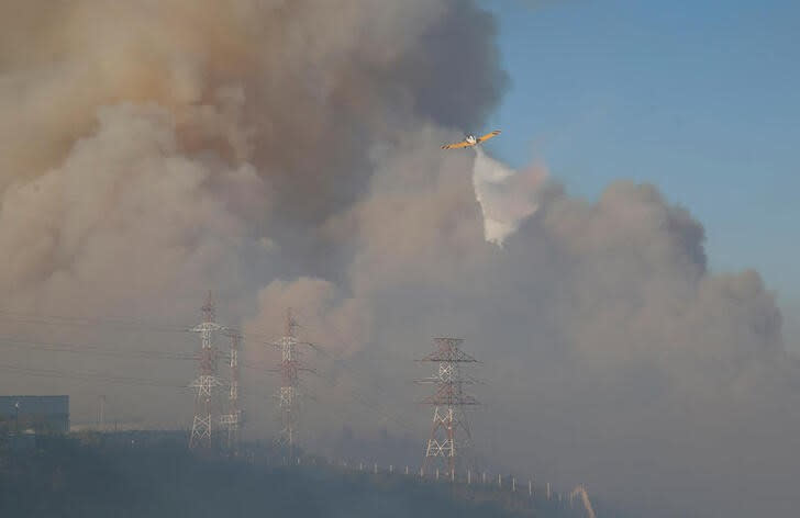 Un avión deja caer agua durante un incendio forestal en Viña del Mar, Chile,