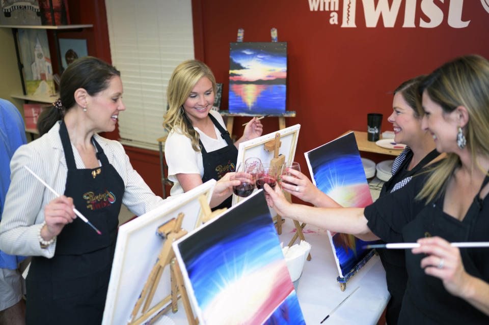 This 2019 photo provided by Painting with a Twist shows a group of women during a Painting with a Twist event in Mandeville, La. In recent years, the interactive painting industry has become a global sensation. Around the world, adults can spend their nights out learning to paint in a relaxed, BYOB setting. Thousands of franchises exist to help us all unleash our inner creative. (Painting with a Twist via AP)