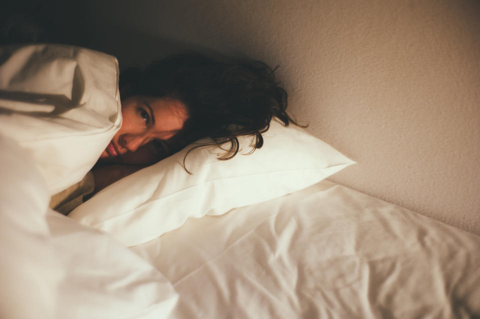 Beautiful young woman lying in bed.