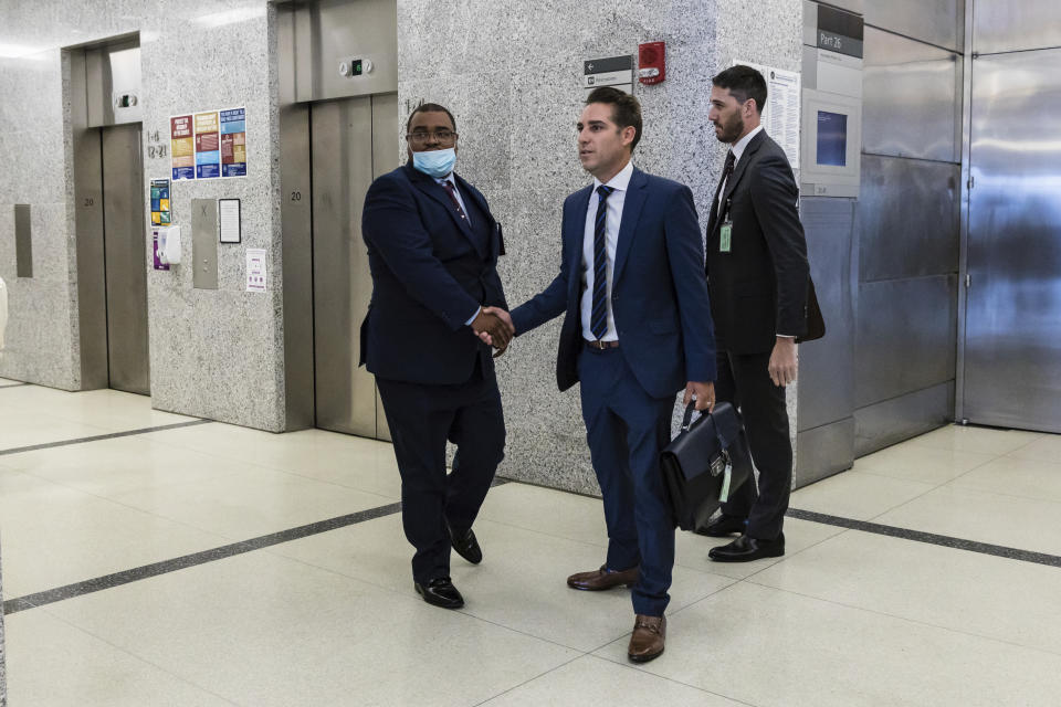 CORRECTS NAME TO LOUIS SCARCELLA NOT VINCENT SCARCELLA - Eliseo DeLeon is greeted by his lawyer Cary London in the hallway at the Kings County Supreme Court in the Brooklyn borough of New York on Wednesday Aug. 31, 2022. Justice Dena Douglas rendered a guilty verdict in the first retrial to result from almost a decade of scrutiny of former New York City homicide detective, Louis Scarcella, who was seen as a case-cracking star in the 1980s and '90s, but was later accused of framing suspects. (AP Photo/Stefan Jeremiah)