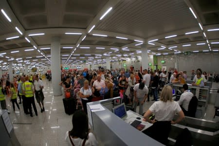 Passengers are seen at Thomas Cook check-in points at Mallorca Airport after the world's oldest travel firm collapsed, in Palma de Mallorca