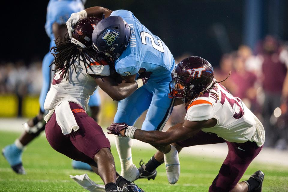 Old Dominion running back Blake Watson (2) is brought down by Virginia Tech defensive back Nasir Peoples (5) and linebacker Jayden McDonald (38) during a game on Sept. 2, 2022, in Norfolk, Va.