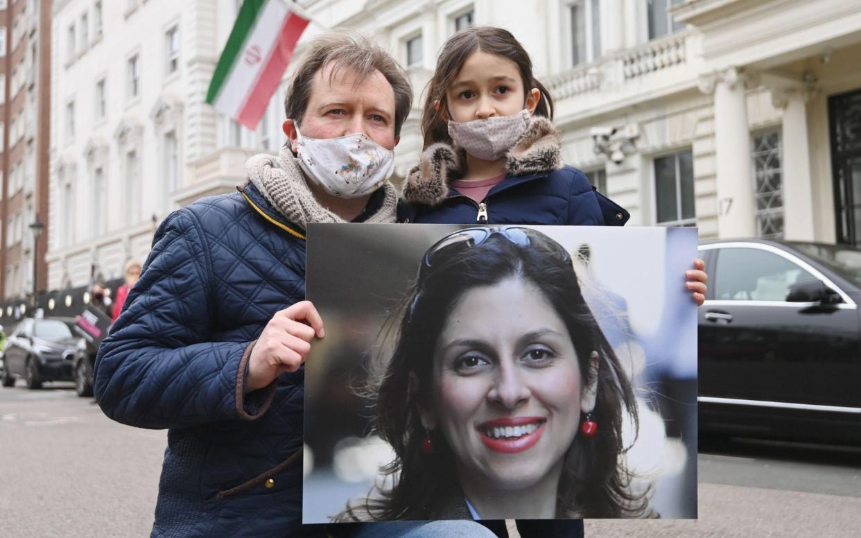 Richard Ratcliffe protests outside the Iranian embassy with the couple's daughter Gabriella on Monday - Shutterstock