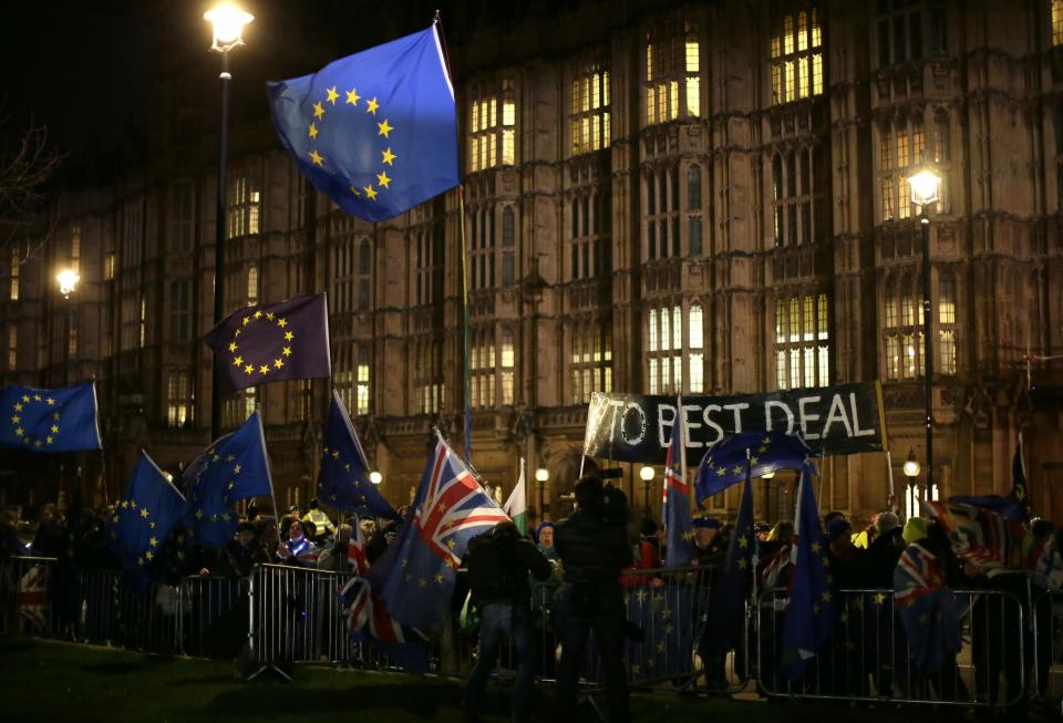 Pro and anti-Brexit supporters gather outside the Houses of Parliament in London, Wednesday, March 13, 2019. Britain's Parliament will vote later Wednesday on whether to rule out leaving the EU on March 29 without a deal. (AP Photo/Tim Ireland)