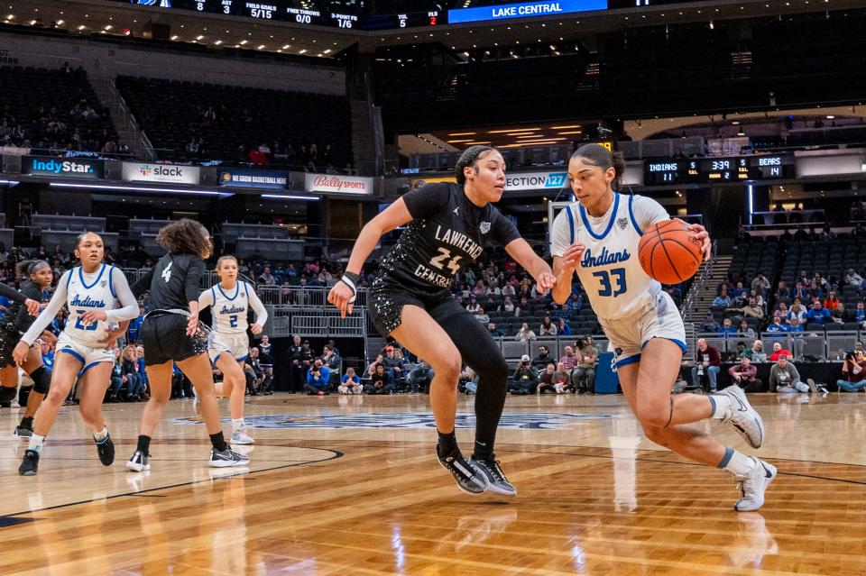 Lake Central high School senior Aniyah Bishop (33) drives the ball along the baseline while being defended by Lawrence Central High School sophomore Aniyah Mckenzie (24) during the first half of an IHSAA class 4A girls’ basketball state finals game, Saturday, Feb. 24, 2024, at Gainbridge Fieldhouse, in Indianapolis.