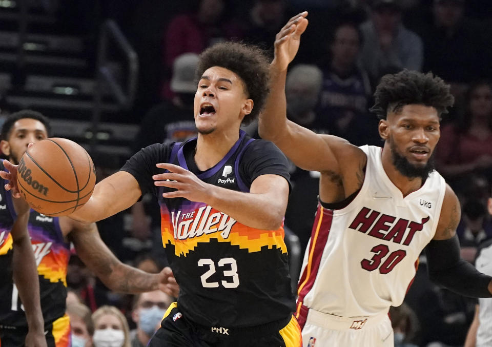 Phoenix Suns' Cameron Johnson (23) reacts after being hit on the head by Miami Heat's Chris Silva (30) during the second half of an NBA basketball game Saturday, Jan. 8, 2022, in Phoenix. (AP Photo/Darryl Webb)