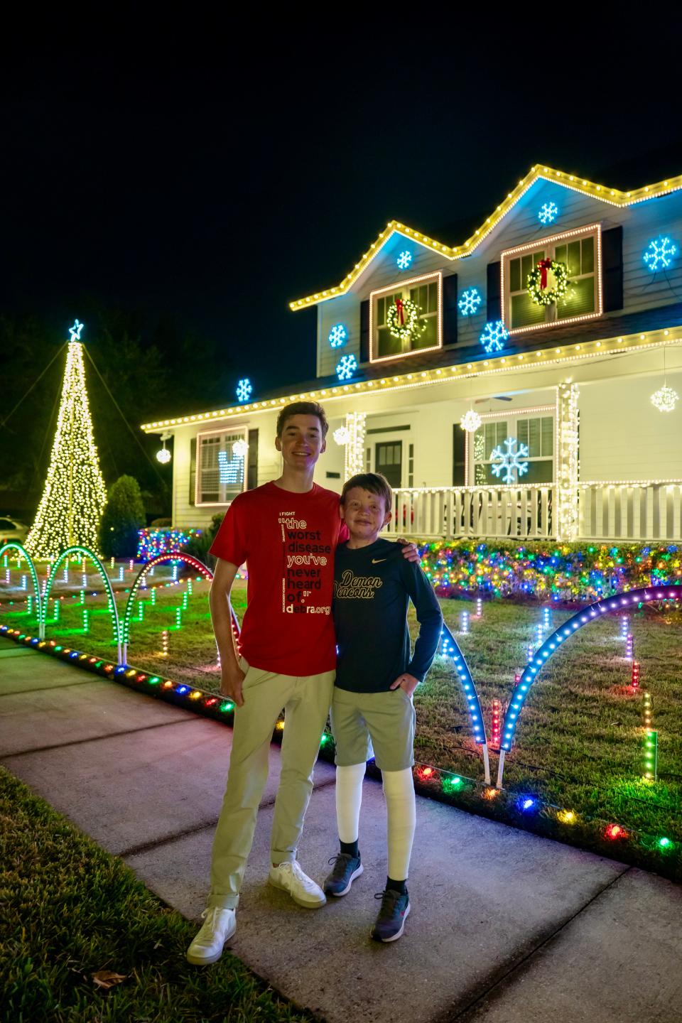 Jonah Williams, right, visited Jacksonville from his home in North Carolina to see the holiday light display created by his cousin, Jack Wheeler, left. Williams suffers from epidermolysis bullosa, a genetic skin condition. Wheeler's display has raised tens of thousands of dollars to fight the disease.