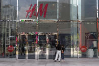 Tourists reading a sign outside a closed H&M outlet in Kuala Lumpur on 18 March 2020, the first day of the Movement Control Order. (PHOTO: Fadza Ishak for Yahoo Malaysia)