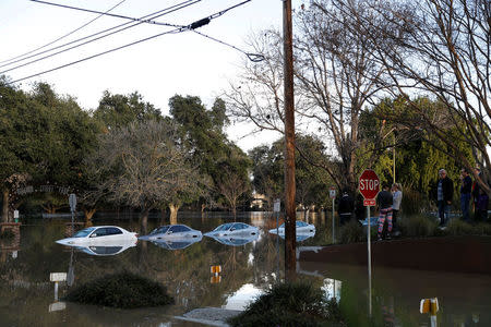 Vehicles are seen partially submerged in flood water at William Street Park after heavy rains overflowed nearby Coyote Creek in San Jose, California. REUTERS/Stephen Lam