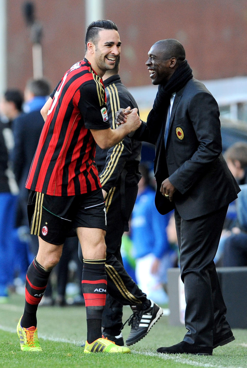 AC Milan's Adil Rami, left, celebrates with coach Clarence Seedorf after scoring a goal during a Serie A soccer match between Sampdoria and AC Milan, at the Luigi Ferraris stadium in Genoa, Italy, Sunday, Feb. 23, 2014. (AP Photo / Carlo Baroncini)