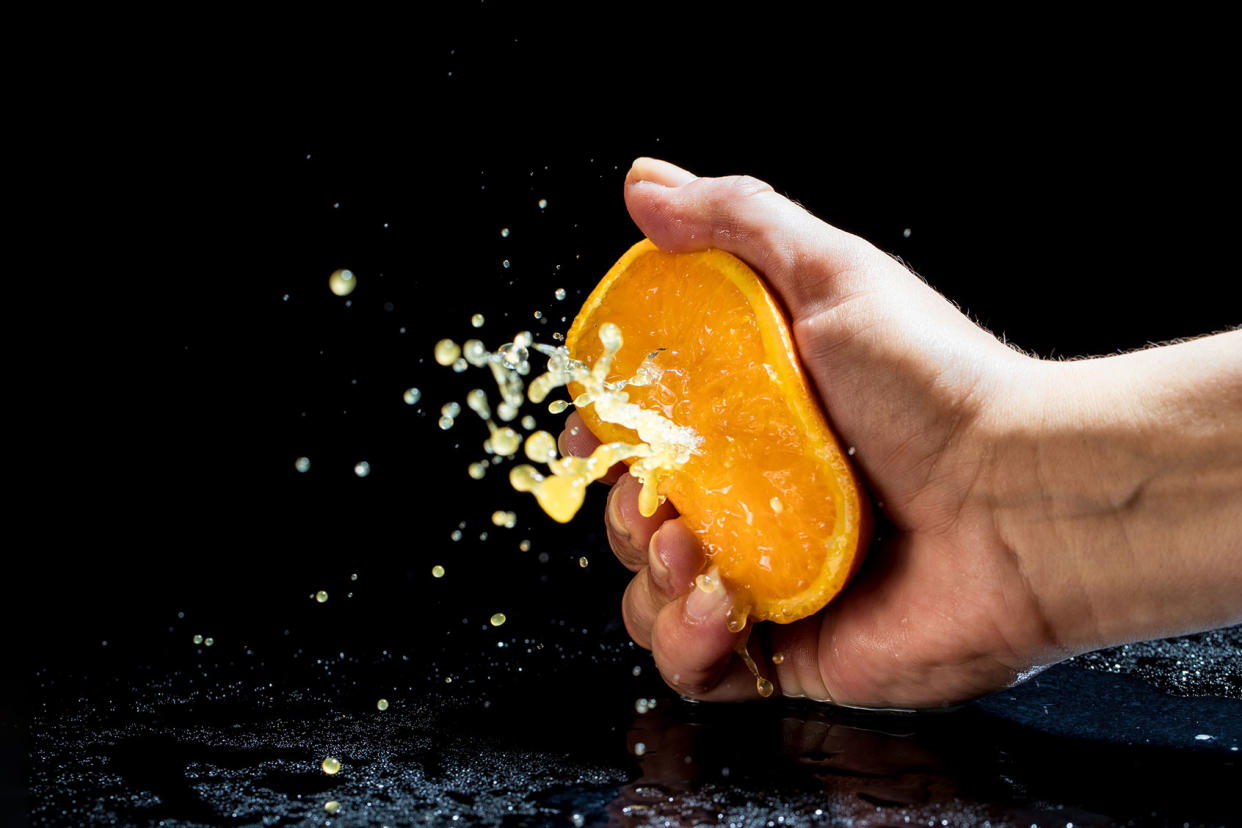 Hand squeezing an orange Getty Images/zoranm