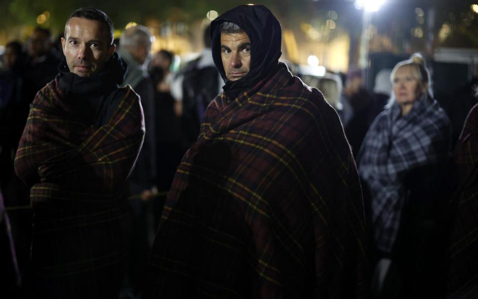 Bundled up against the cold, members of the public near the end of their 12-hour wait as the queue to see Queen Elizabeth II's casket nears an end outside Westminster Hall - Getty Images