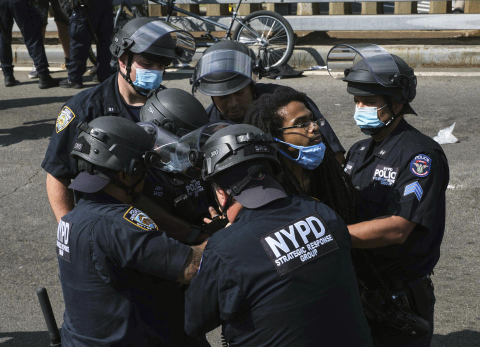 A Black Lives Matter protester is apprehended by NYPD officers on Brooklyn Bridge, Wednesday, July 15, 2020, in New York. Several New York City police officers were attacked and injured Wednesday on the Brooklyn Bridge during a protest sparked by the death of George Floyd. Police say at least four officers were hurt, including the department’s chief, and more than a dozen people were arrested.(AP Photo/Yuki Iwamura)