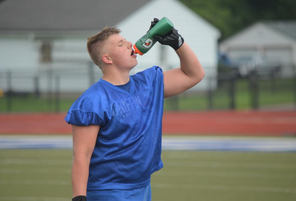 Harper Creek sophomore Zach Kitchen grabs a drink during a break on the first day of preseason two-a-days for football on Monday.