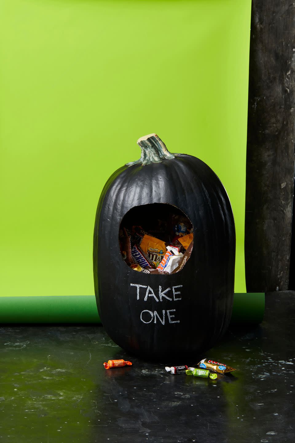 <p>Craft a unique — and useful — front porch display with a large real or faux pumpkin. First, mark a hole on the top half of the pumpkin and carefully cut along the line with a pumpkin carving set. If you opted for a fake pumpkin, sand down any rough edges. Paint the entire pumpkin with black chalk paint and let dry. Before the festivities begin, fill it with candy and write a message with chalk. </p><p><strong>RELATED:</strong> <a href="https://www.goodhousekeeping.com/holidays/halloween-ideas/a22196/pumpkin-carving-tips/" rel="nofollow noopener" target="_blank" data-ylk="slk:How to Carve the Perfect Pumpkin;elm:context_link;itc:0;sec:content-canvas" class="link ">How to Carve the Perfect Pumpkin</a></p>