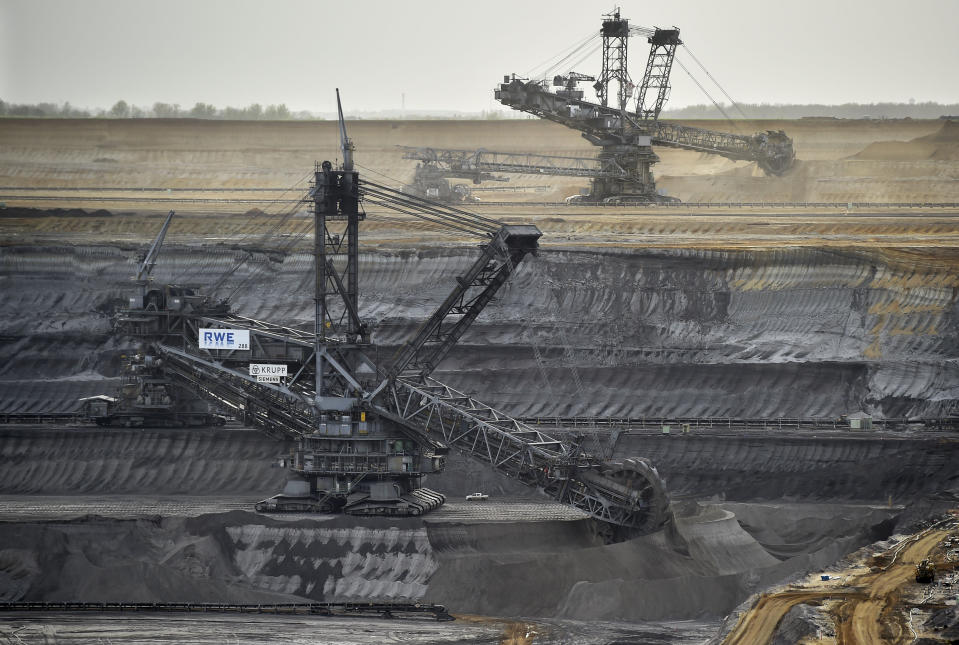 In this picture taken Thursday, April 3, 2014, giant machines dig for brown coal at the open-cast mining Garzweiler near the city of Grevenbroich, western Germany. After concluding that global warming is almost certainly man-made and poses a grave threat to humanity, the U.N.-sponsored expert panel on climate change is moving on to the next phase: what to do about it. The Intergovernmental Panel on Climate Change, or IPCC, startet a meeting in Berlin Monday, April 7, 2014,to chart ways for the world to rein in the greenhouse gas emissions that scientists say are overheating the planet. (AP Photo/Martin Meissner)