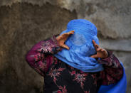 <p>Una niña intenta mirar a través de los agujeros de su burka en una calle de Kabul (Afganistán). (Foto: Anja Niedringhaus / AP). </p>