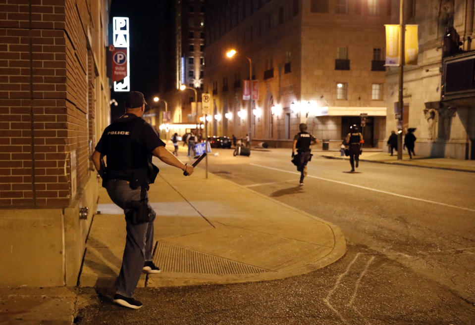 FILE - In this Sept. 17, 2017 file photo, police chase vandals as demonstrators march in response to a not guilty verdict in the trial of former St. Louis police officer Jason Stockley in St. Louis. Stockley was acquitted in the 2011 killing of a black man following a high-speed chase. Four St. Louis police officers were indicted Thursday, Nov. 29, 2018, by a federal grand jury. Three are accused of beating an undercover colleague during a protest over the acquittal of Stockley, a white officer who was accused in the death of a black suspect. Those three and a fourth officer are also accused of conspiring to cover up the crime. (AP Photo/Jeff Roberson, File)