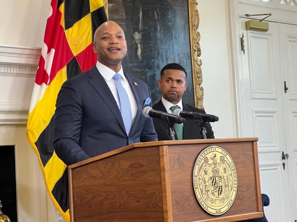 Gov. Wes Moore speaks at the lectern while introducing Paul Monteiro, at right, as his nominee to lead the new Department of Service and Civic Innovation. Moore has made making a service year option for high school graduates a centerpiece of his administration.