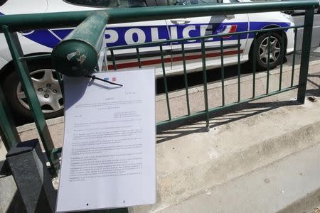 A French police car is parked near an official document from the Prefecture informing the public of the closure of the beach called "La Mirandole" which is located below the seafront villa owned by the king of Saudi Arabia in Vallauris Golfe-Juan, France, July 25, 2015. REUTERS/Jean-Paul Pelissier