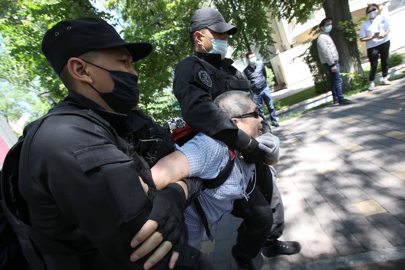 Kazakh law enforcement officers detain a man during an opposition rally in Almaty